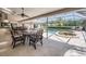 Inviting covered patio with outdoor seating, dining area, and a view of the pool and spa at 1307 Forestedge Blvd, Oldsmar, FL 34677