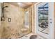 An elegant glass shower with travertine tiles and a seat, perfect for relaxation with a view of the pool at 1307 Forestedge Blvd, Oldsmar, FL 34677