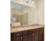 Primary bathroom featuring granite countertops, dark wood cabinets, and separate glass shower at 13611 Circa Crossing Dr, Lithia, FL 33547
