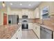 Modern kitchen with stainless steel appliances, tile backsplash, and granite countertops at 13611 Circa Crossing Dr, Lithia, FL 33547