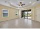 Open living room with tiled flooring, ceiling fan and sliding doors to the outside at 13611 Circa Crossing Dr, Lithia, FL 33547