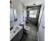 Stylish bathroom with updated tile shower, modern vanity and pebble stone flooring at 1417 W Curlew Pl, Tarpon Springs, FL 34689