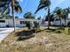 Charming single-story home with mature landscaping, palm trees and a well-manicured lawn at 1417 W Curlew Pl, Tarpon Springs, FL 34689