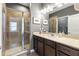 Modern bathroom featuring a glass-enclosed shower, dark wood cabinets, and a neutral-toned countertop at 14616 Rocky Brook Dr, Tampa, FL 33625