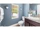 Charming powder room featuring granite countertops, blue accent wall, and stylish decor at 14616 Rocky Brook Dr, Tampa, FL 33625
