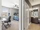 View of a bedroom with neutral walls, carpet flooring, ceiling fan, workspace, and an adjoining bathroom at 14616 Rocky Brook Dr, Tampa, FL 33625