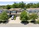 View of tan townhouses with well-maintained landscaping and driveways beneath a clear sky at 14616 Rocky Brook Dr, Tampa, FL 33625