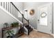 Elegant foyer featuring a staircase with decorative wooden console table and contemporary mirror at 14616 Rocky Brook Dr, Tampa, FL 33625