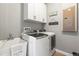 Well-equipped laundry room with modern appliances, overhead cabinets, and a convenient utility sink at 14616 Rocky Brook Dr, Tampa, FL 33625