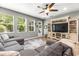 Living room with a grey sectional sofa, ceiling fan, and a large entertainment center at 14616 Rocky Brook Dr, Tampa, FL 33625