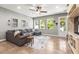 Living room featuring a comfortable gray sectional sofa, ceiling fan and access to the backyard at 14616 Rocky Brook Dr, Tampa, FL 33625
