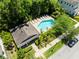Aerial view of a kidney-shaped pool surrounded by lounge chairs and tropical landscaping at 14616 Rocky Brook Dr, Tampa, FL 33625