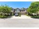 Charming townhomes with manicured lawns, driveway and attached garages under a clear blue sky at 14616 Rocky Brook Dr, Tampa, FL 33625