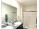 Bright bathroom features a double sink, granite countertops, and a walk-in shower at 1490 Colt Creek Pl, Wesley Chapel, FL 33543