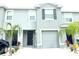 Modern townhome featuring a one-car garage, a neutral color scheme, and simple landscaping at 1490 Colt Creek Pl, Wesley Chapel, FL 33543