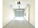 Clean, empty garage with sealed concrete floors and a functional garage door at 1490 Colt Creek Pl, Wesley Chapel, FL 33543