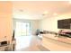 Open-concept living area with tile floors and natural light streaming through sliding glass doors at 1490 Colt Creek Pl, Wesley Chapel, FL 33543