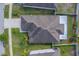 Detailed aerial shot focuses on a home's roof and backyard, highlighting the property lines and surrounding greenery at 15430 Long Cypress Dr, Ruskin, FL 33573