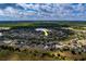 Expansive aerial view of a residential community near a scenic lake and lush greenery, arrow points to property at 15430 Long Cypress Dr, Ruskin, FL 33573