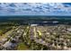 High aerial view of a neighborhood close to a lake with abundant trees, arrow points to property at 15430 Long Cypress Dr, Ruskin, FL 33573