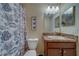 Well-lit bathroom with a shower/tub combo and a wooden vanity with granite countertops at 15430 Long Cypress Dr, Ruskin, FL 33573