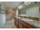 Bathroom featuring a double sink vanity, granite countertop, and a walk-in shower at 15430 Long Cypress Dr, Ruskin, FL 33573