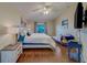 Bright bedroom features wood floors, ceiling fan, and a cozy chaise lounge at 15430 Long Cypress Dr, Ruskin, FL 33573