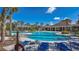 Inviting community pool with ample seating, lush palms, and a pergola providing shade for relaxing by the water at 15430 Long Cypress Dr, Ruskin, FL 33573