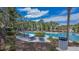 Relaxing community pool area with ample lounge chairs, lush landscaping, and a serene atmosphere for residents at 15430 Long Cypress Dr, Ruskin, FL 33573