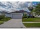 Charming single-story home featuring a two-car garage, well-maintained lawn, and beautiful landscaping at 15430 Long Cypress Dr, Ruskin, FL 33573