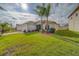 Well-manicured front yard with lush green grass and palm trees enhancing the curb appeal of the home at 15430 Long Cypress Dr, Ruskin, FL 33573
