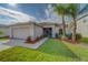Charming single-story home featuring a well-manicured lawn, lush landscaping, and lovely palm trees at 15430 Long Cypress Dr, Ruskin, FL 33573