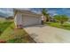 Attached garage with driveway and landscaping in front of a cozy, well-maintained home at 15430 Long Cypress Dr, Ruskin, FL 33573