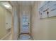 Hallway features a glass-paned door and a coastal-themed painting, offering a glimpse into the home's style at 15430 Long Cypress Dr, Ruskin, FL 33573