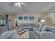 Relaxing living room featuring a sectional sofa, coastal-themed artwork, and ample natural light at 15430 Long Cypress Dr, Ruskin, FL 33573