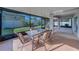 Screened-in patio with glass table set and chairs overlooking the backyard at 15430 Long Cypress Dr, Ruskin, FL 33573