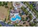 Aerial view of community pool, playground and amenity center with lush landscaping and ample parking at 15430 Long Cypress Dr, Ruskin, FL 33573
