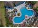 Aerial view of a resort-style pool with lush landscaping, sun loungers, and a tranquil atmosphere at 15430 Long Cypress Dr, Ruskin, FL 33573