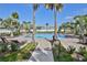 Resort-style pool with lush landscaping, lounge chairs, and palm trees creating a relaxing oasis at 15430 Long Cypress Dr, Ruskin, FL 33573