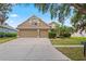 Charming two-story home featuring a three-car garage, manicured lawn, and mature landscaping at 16119 Bridgedale Dr, Lithia, FL 33547