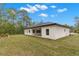 The home's backyard features a covered patio and lush green grass surrounding the home at 16431 Penn State Rd, Weeki Wachee, FL 34614