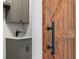 Rustic barn door with black hardware partially obscuring view of gray cabinets with white countertop at 16431 Penn State Rd, Weeki Wachee, FL 34614