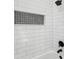 Bathroom shower featuring white subway tile, black showerhead, and built-in niche at 16431 Penn State Rd, Weeki Wachee, FL 34614
