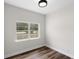 This bedroom features light grey walls, wood-look floors, a white ceiling, and a bright window at 16431 Penn State Rd, Weeki Wachee, FL 34614