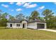 Well-maintained single-story home with neat landscaping and a two-car garage in a lush setting at 16431 Penn State Rd, Weeki Wachee, FL 34614