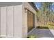 Close up on the side of the house with a large garage door and a well manicured garden at 16431 Penn State Rd, Weeki Wachee, FL 34614