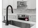 Close-up of a kitchen sink with modern faucet and stainless steel oven behind it at 16431 Penn State Rd, Weeki Wachee, FL 34614