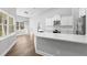 Open kitchen with white cabinets, stainless steel appliances, breakfast bar, and wood flooring at 16431 Penn State Rd, Weeki Wachee, FL 34614