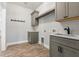 Laundry room with gray cabinets, a stainless steel utility sink, and unique brick flooring at 16431 Penn State Rd, Weeki Wachee, FL 34614