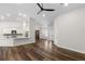 Bright living room featuring hardwood floors, neutral walls, and a seamless flow into the kitchen at 16431 Penn State Rd, Weeki Wachee, FL 34614